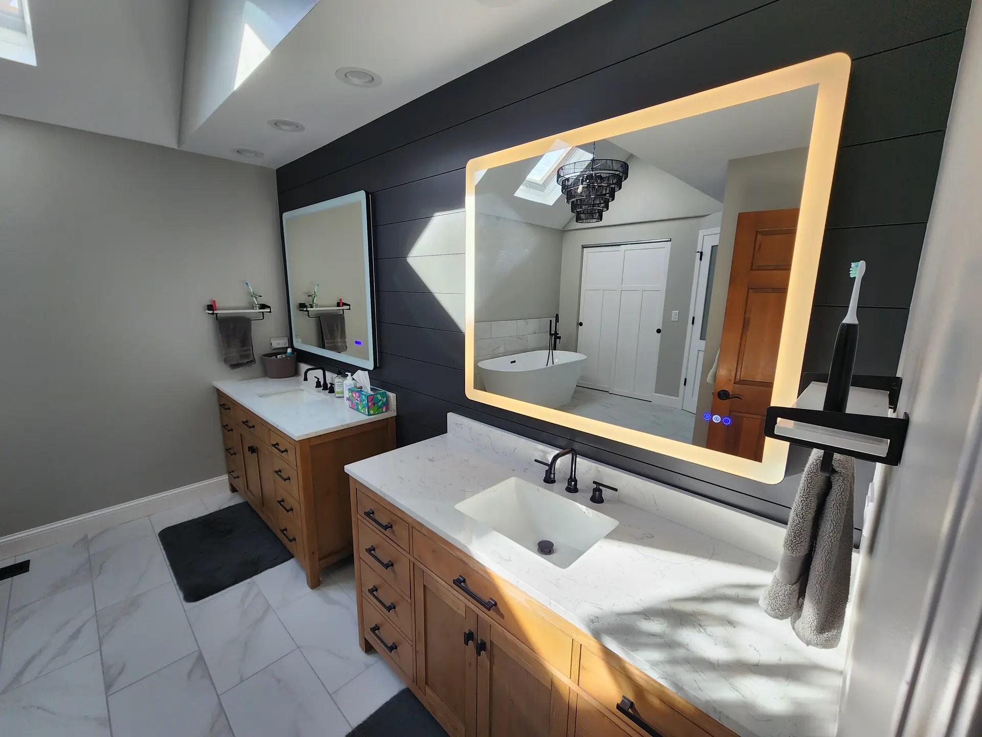 Renovated bathroom with dark shiplap accent wall and custom wood vanity