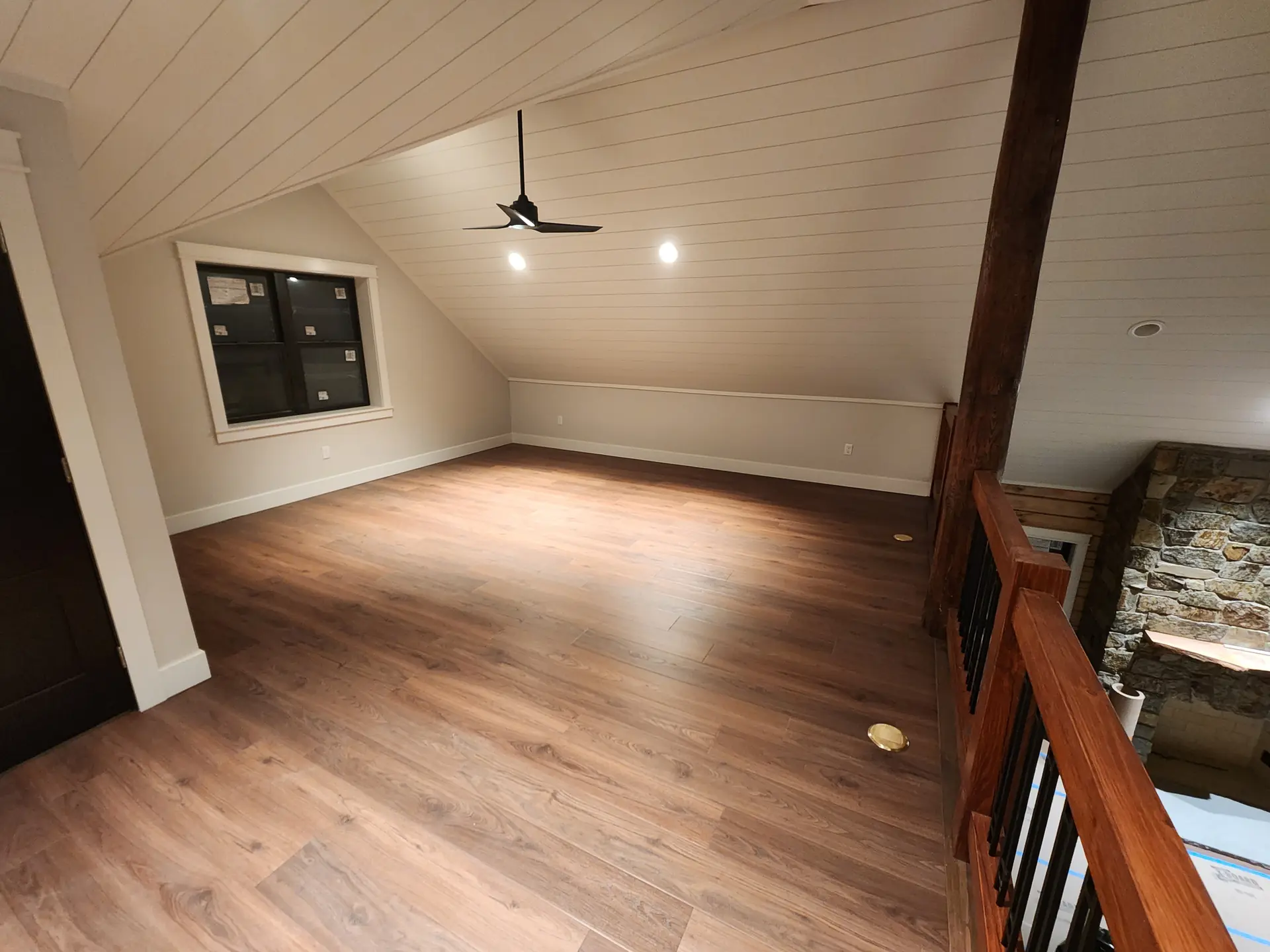 Vaulted bonus room with white shiplap ceiling and new hardwood flooring