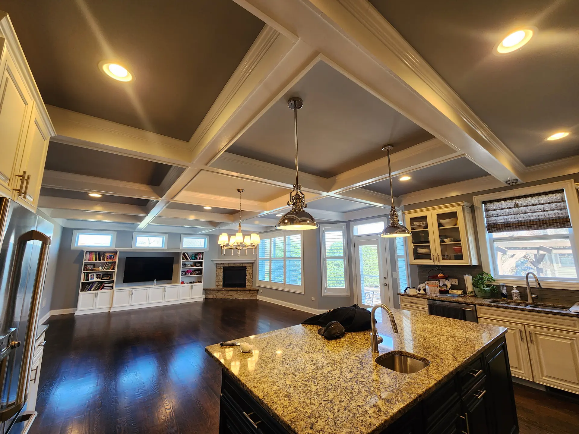 Kitchen and great room with custom coffered ceiling and built-in shelving